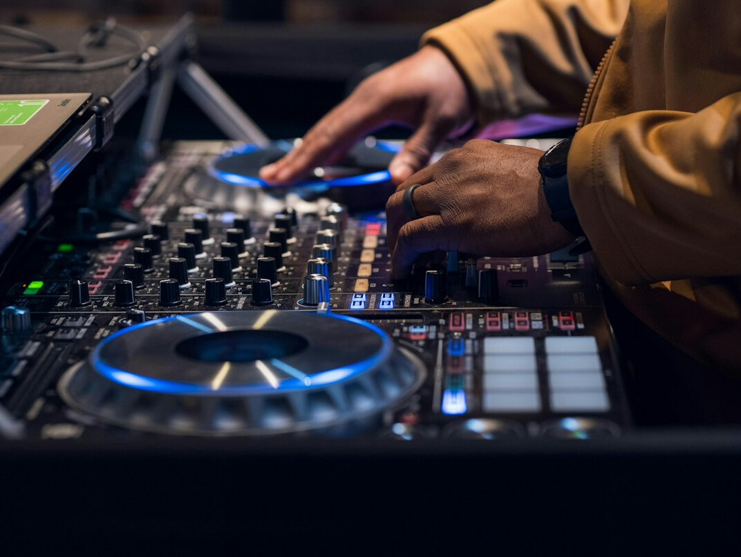 Hands adjusting sliders on a video mixing console